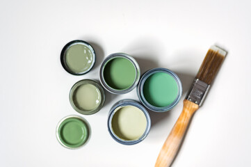 Tiny sample paint cans during house renovation, process of choosing paint for the walls, different...