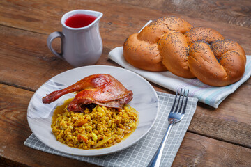 Wicker challah on the table and a plate with boiled spelt with a duck leg and a jug of wine.