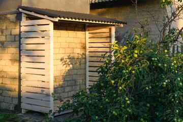 Empty firewood rack for storing firewood in the garden at sunset for the heating season. Timber construction with a slate roof. The concept of logging for the winter. Energy crisis