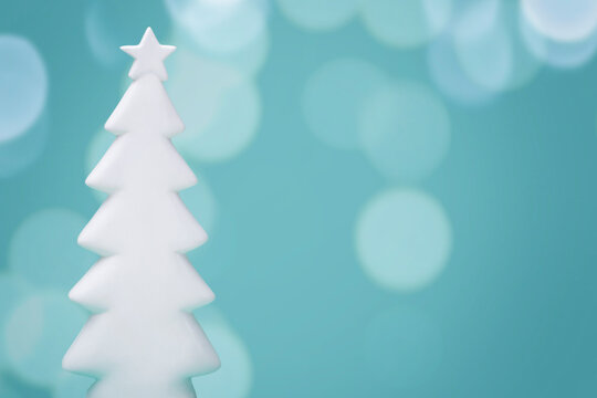 White Christmas Tree On Blue Teal Background With Bokeh Glow