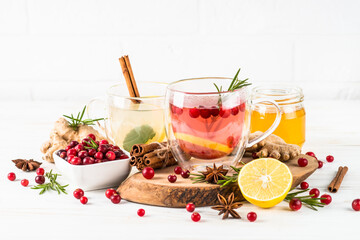 Cranberry tea with lemon and rosemary in glass mug. Healthy hot vitamin drink.