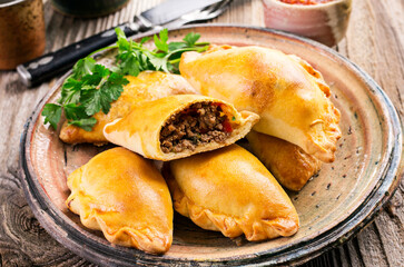 Traditional Spanish baked empanada de carne with minced meat and vegetable served as close-up on a...
