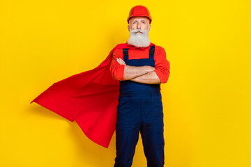 Photo of strong serious age man wear overall uniform red hard hat cape arms crossed isolated yellow...