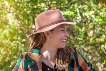 Portrait Of A Beautiful Woman With Smiling Face In Casual Clothes. Happy Woman Looking Away With Hat In A City Park. Sunny Autumn Day