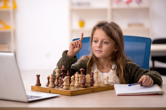 Young Little Girl Playing Chess At Home