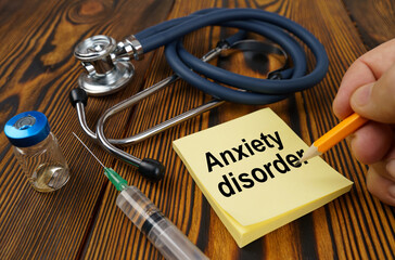 On the table is a stethoscope, a syringe and a sticker with the text - Anxiety disorder