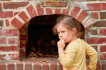 cute young girl playing with a brick stove at a farming exhibition