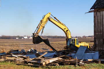 Close up view of an excavator used in the demolition of an old abandoned barn building  © Cynthia