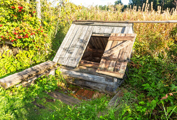 Fototapeta na wymiar Old wooden water well at the countryside in summer
