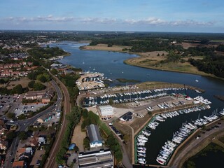 Aerial shot of a city with a big river and boats on the dock during the daytime - Powered by Adobe