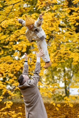 Happy child and his dad having fun outdoors in the park, both smiling and laughing. Concept of family values, love and happiness.