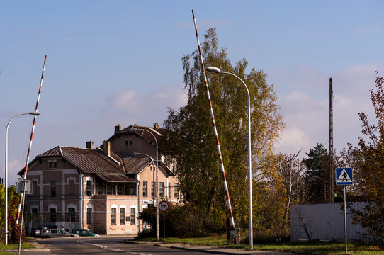 Stara  ,zniszczona ( choć przewidziana do remontu !) stacja kolejowa w Ostrowcu Świętokrzyskim . Dworzec widoczny w "ramie" szlaban&oacute;w kolejowych i w otoczeniu pięknie wybarwionych drzew jesienią .