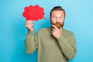 Portrait of thoughtful positive man with red hairstyle khaki pullover look at dialogue cloud hand...