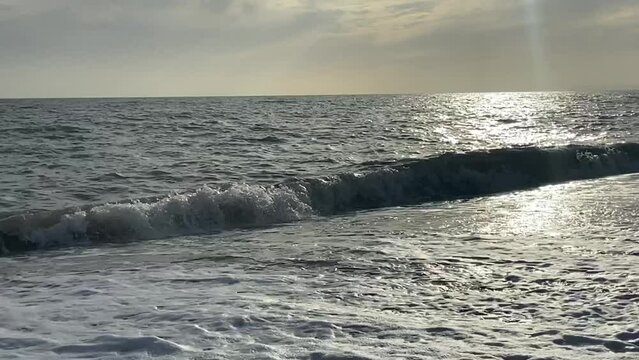 beach ocean waves on shingle pebble UK - popular summer beach destination rugged coast on south of England - stock footage