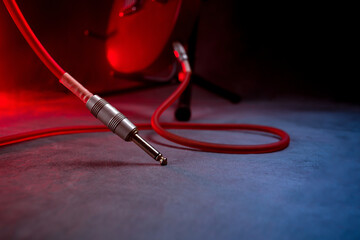 The guitar standing on the stage and one end of the jack cable connected to it are not plugged into the amp.