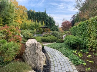 oriental landscape with carved pavement, natural stone boulders, gazebo and traditional east...