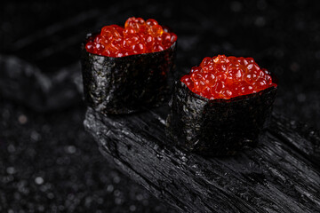 sushi red caviar on black background