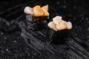 scallop sushi on black background
