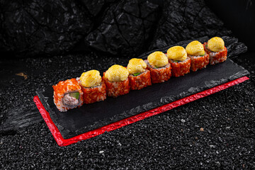 Asian cuisine. Rolls Yamagata. Rice nori caviar tobiko crab avocado parmesan on a black background.