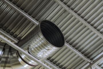 Galvanized round ventilation duct in an industrial building. Engineering air system.