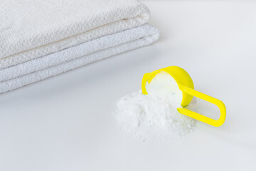 Flatlay of laundry detergents powder with fresh towels