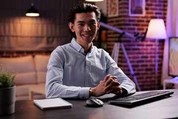 Obraz premium Portrait of freelancer doing remote job at home, using computer to plan business report on online website. Creating research data plan on pc monitor, working remotely on startup company.