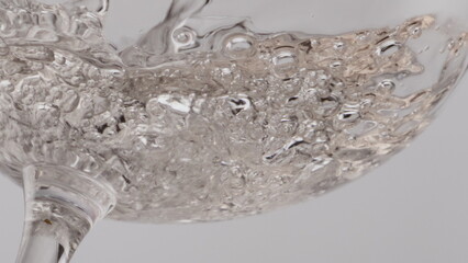 Champagne bubbling crystal wineglass closeup. Wine sparkling transparent goblet 