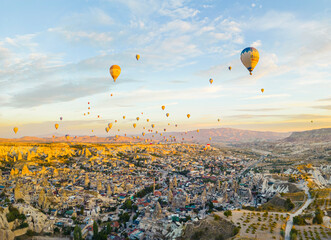 Spectacular drone view of hot air balloons ride over Turkey's iconic Cappadocia, the underground cities and fairy chimneys valley, rock formations. High quality photo