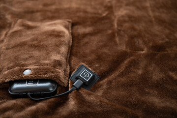 electric blanket with portable charger as a power supply at horizontal composition