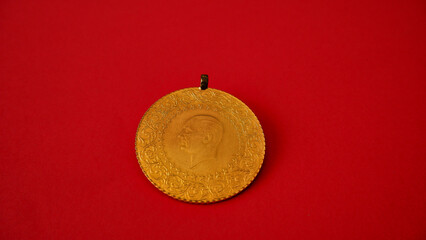 Turkish gold coin on the red or vermilion background, isolated, closeup and top view photo.
