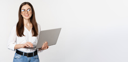 Portrait of young office woman, entrepreneur answer clients on laptop, working with computer with...