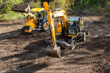 Bulldozer and excavator at the construction site at the earthworks at the construction site....