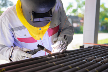 The welder is welding the plate to the pipe with Gas Tungsten Arc Welding (GTAW). The welder wears...