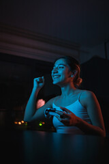 young gamer girl excitedly playing console game and winning and happy
