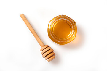 Jar of honey and dipper isolated on white background. top view
