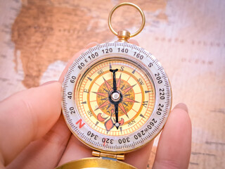 Close up of golden compass on vintage map,travel concept