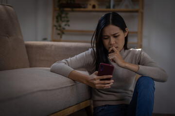 Sad or heart broken Asian woman or Asian girl sitting on a sofa in the living room, anxiety, Loneliness, burnout , Depression, mental health, Sad, tired.