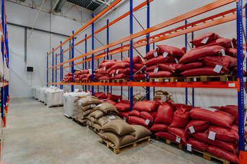 Bags with production on shelves in warehouse. Bags with coffee beans or sugar or other