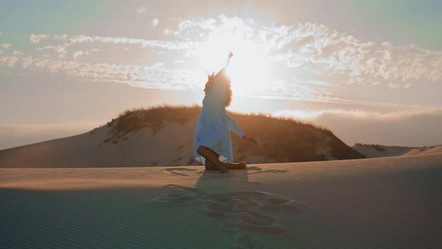 Silhouette woman dancing sunset in desert. Girl performing emotional dance.
