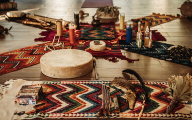 Sacred Maya ceremony items displayed on wooden floor with colorful blankets, percussion instrument...