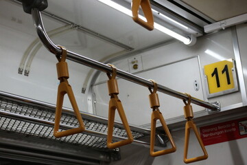 The hand handle or handgrips or handrails of commuter line passengers swaying due to the movement...