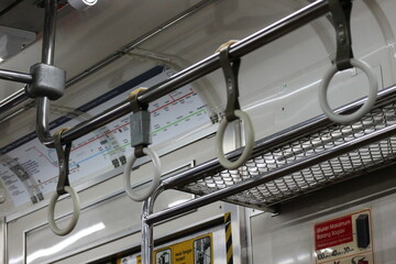The hand handle or handgrips or handrails of commuter line passengers swaying due to the movement of the train.
