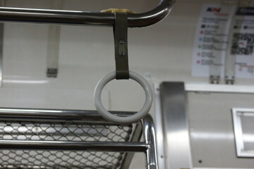 The hand handle or handgrips or handrails of commuter line passengers swaying due to the movement of the train. © CindhyAde