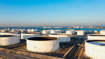 Aerial top view of White oil tank storage chemical petroleum petrochemical refinery product at oil terminal. Oil terminal storage tank in deep seaport for the international order concept.  - obrazy, fototapety, plakaty
