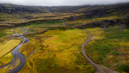 birdview of tundra field and clouds over mountain ridge,  roads and rivers meandering