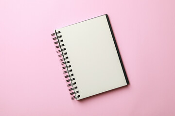 Blank notebook on pale pink background, top view