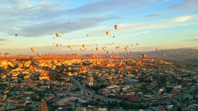 gorgeous aerial shot of dozens of colorful air balloons flying over Cappadocia's rocky landscape. High quality 4k footage