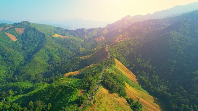 Drone fly over "Loi Fah Road", It is a beautiful country road and a famous tourist attraction. Nan, Thailand. high agricultural areas and tropical forest. green background in sunlight. travel concept
