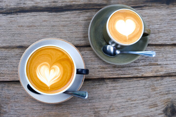 Two cups of coffee on wooden background with beautiful latte art