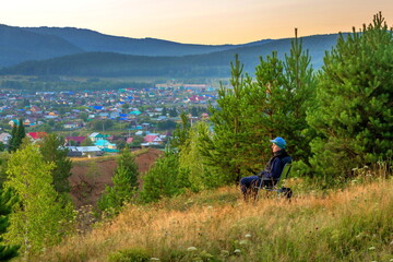 Sunny sunrise over the Ural mountains over the village of Inzer on a summer day